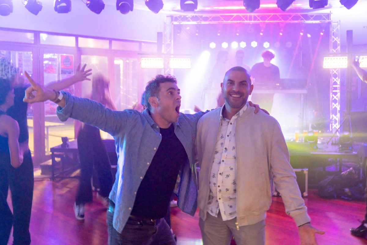 Two guests dancing under light beams on the dance floor